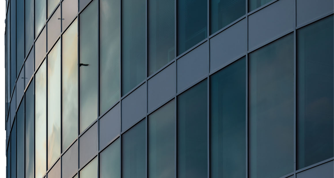 Současná architektura proti modré obloze, ilustrující expertízu Grinity v oblasti realit a stavebního poradenství.